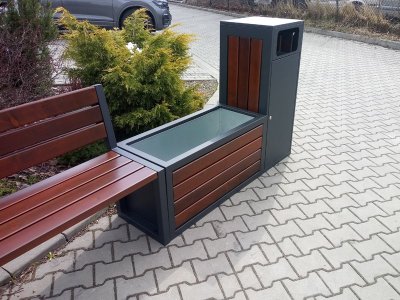 Parkbänk med blomkruka och sopkorg